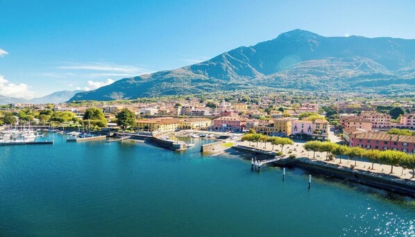 Une ville côtière dotée d’un port de plaisance, de bâtiments le long du front de mer et de montagnes en arrière-plan.