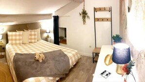 Un dormitorio con cama, mesitas de noche, una lámpara y una alfombra pequeña.