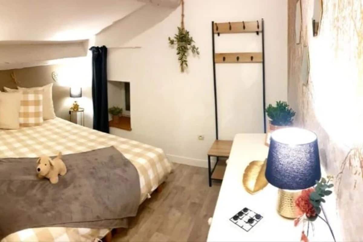 Une chambre à coucher avec un lit, des tables de chevet, une lampe et un petit tapis.