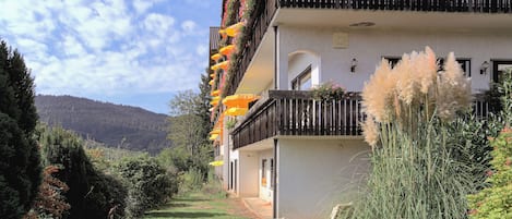 A multi-story building with balconies adorned with flowers and outdoor furniture.
