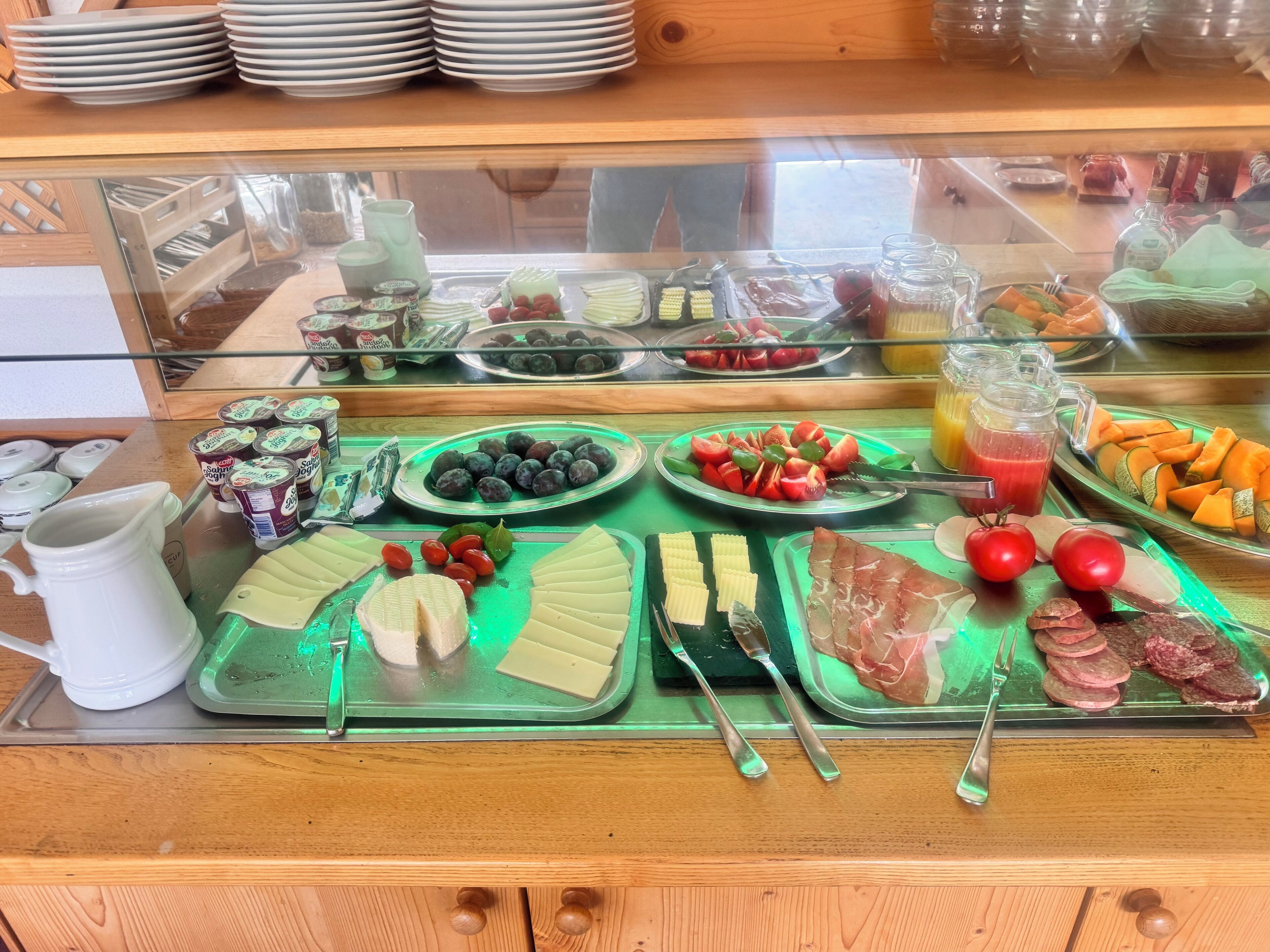 Ein reichhaltiges Frühstücksbuffet mit Speisen und Besteck.