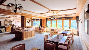 Un comedor amplio con muebles de madera y ventanas grandes que ofrecen vistas al campo.