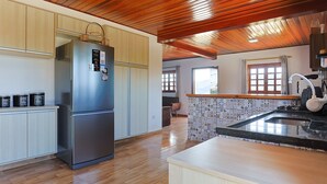 Een moderne keuken met houten vloer, een roestvrijstalen koelkast en een betegelde achterwand.