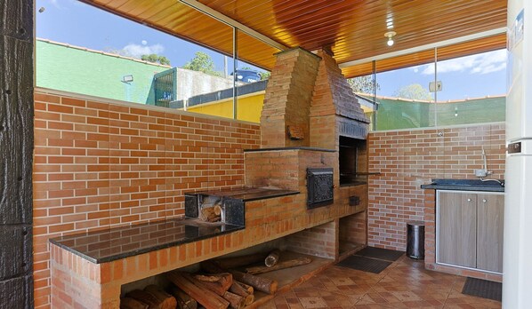 Una cocina con horno de ladrillo, mostrador de madera y vistas al exterior.