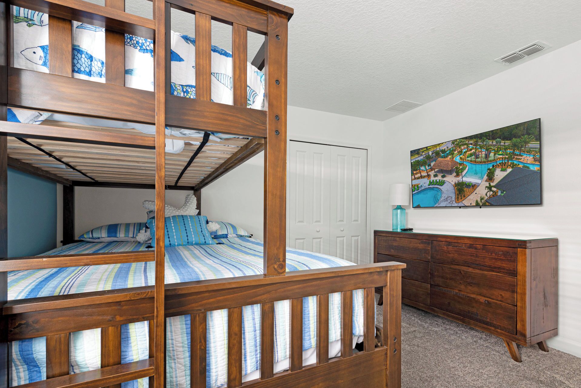 Una habitación con literas, un aparador y un cuadro de un resort.