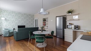 Une cuisine moderne équipée d’un réfrigérateur, d’un four à micro-ondes et d’un petit coin repas avec une table et des chaises.
