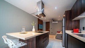 A modern kitchen with a central island, stainless steel appliances, and dark wood cabinetry. - 1 Br Condo with Rooftop Pool & Bar - IT (Playa del Carmen)