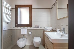 Ein modernes Badezimmer mit integriertem Bidet, Toilette und Waschbecken.