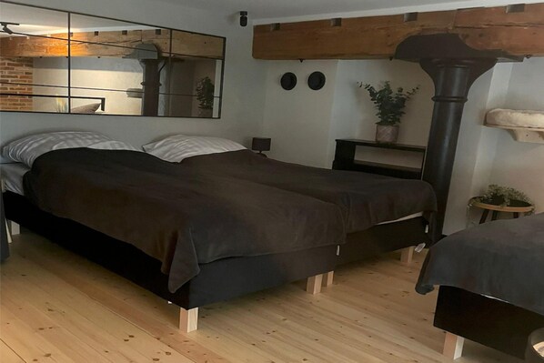 A bedroom with a bed, a mirror, a heater, and a potted plant. - A Comfortable Apartment in the Heart of the City (Łódź)