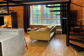 A modern living room with a sofa, a coffee table, and a fireplace. - A Comfortable Apartment in the Heart of the City (Łódź)