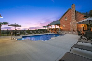 A pool area with lounge chairs and a covered seating area. - The View at Grizzly Mountain | Hocking Hills, Pool (Creola)