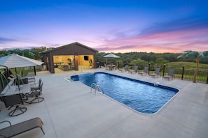 A swimming pool with lounge chairs and a covered area with tables and chairs. - The View at Grizzly Mountain | Hocking Hills, Pool (Creola)