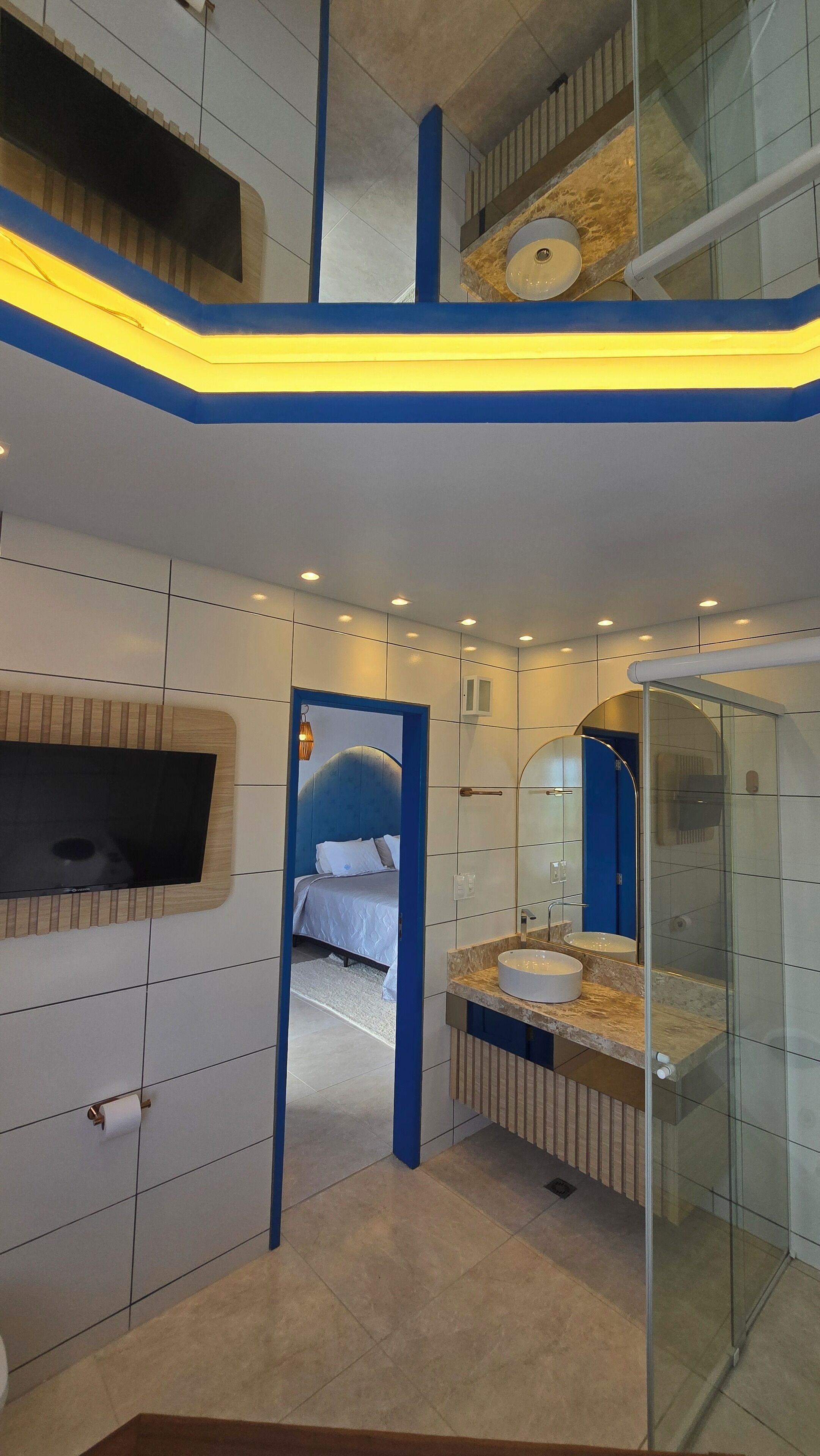 A modern bathroom with a large mirror, a sink, and a shower.