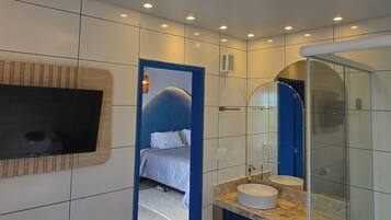 A modern bathroom with a large mirror, a sink, and a shower.