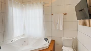 A modern bathroom with a wooden bathtub, a toilet, and a shower curtain.