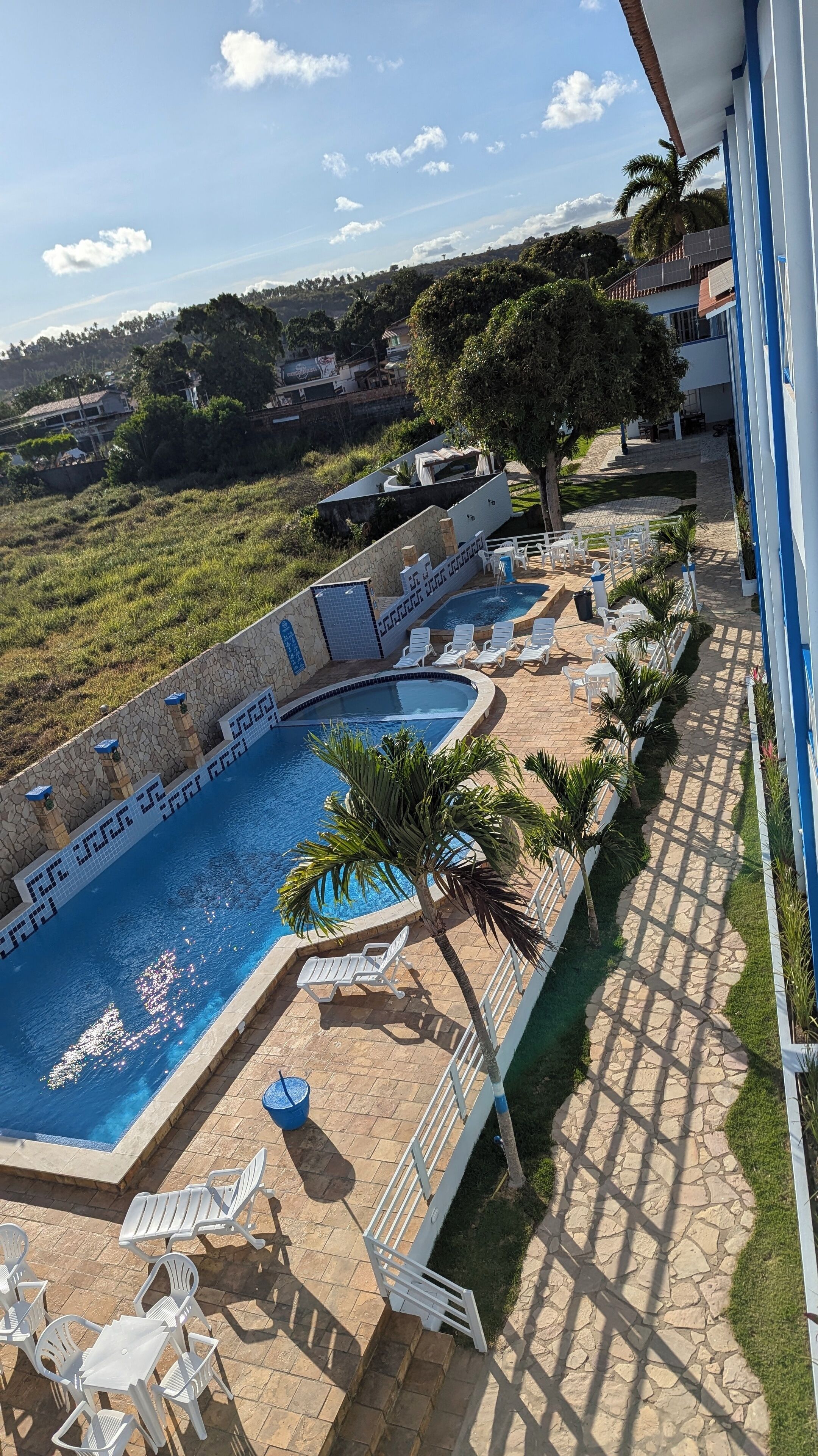 Una piscina con lettini e un vialetto in pietra.