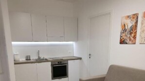 A compact living space with a kitchenette, a sofa, and a dining table. - Villa Ada - Apartment 'Simona' with Private Terrace, Wi-Fi and Air Conditioning (Selva di Fasano)