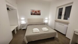 A bedroom with a bed, bedside tables, a window, and a painting on the wall. - Villa Ada - Apartment 'Simona' with Private Terrace, Wi-Fi and Air Conditioning (Selva di Fasano)