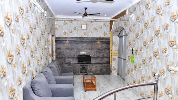 A modern living room with a sofa set, a TV, and a fireplace. - Arunai Grand Tiruvannamalai (Tiruvannamalai)
