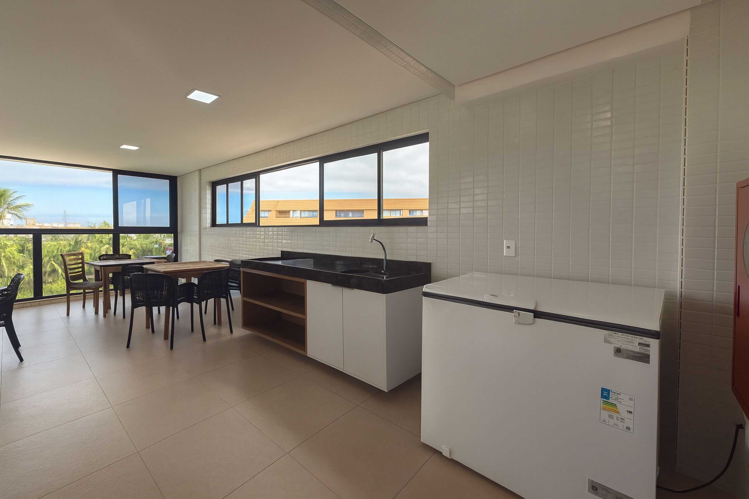 A modern kitchen with a dining area, large windows, and a view of the city.