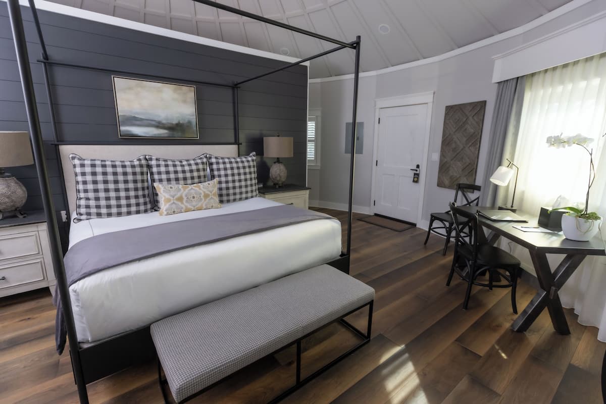 Un dormitorio con cama con dosel, un escritorio y una silla.