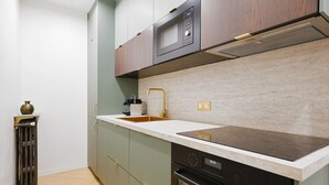 A modern kitchen with a built-in microwave, stainless steel sink, and a dishwasher. - 606 Aaron Suite - Apartment near the Eiffel Tower (Paris)