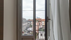 A window with a view of buildings and a street. - Italianway - Bramante 29 (Milan)