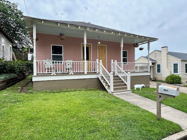 A two-story house with a front porch, a small staircase, and a mailbox. - Historic Cottage (Vicksburg)