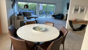 A dining area with a round table, wicker chairs, and a ceiling fan. - 3-bedroom/3-Bathroom condo in amazing Palm Springs with mountain views! (Palm Springs)