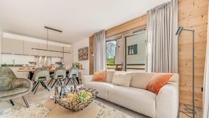 A modern living room with a sofa, dining area, and kitchen. - View village, balcony, tv, ski locker, 68m², Champagny-en-Vanoise (Champagny-en-Vanoise)