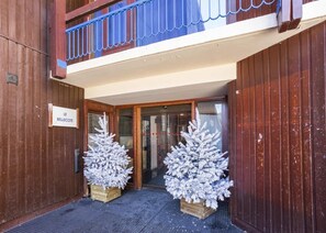 Puinen rakennus, jonka yläpuolella on kyltti, jossa lukee ”LE BELLECOTE”, ja sen edessä on kaksi valaistua, koristeellista joulukuusta.