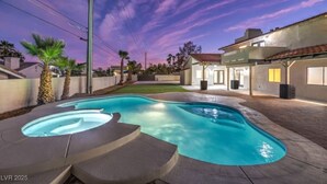 A swimming pool with a hot tub, surrounded by a patio area and a house with a red-tiled roof. - LUX 5BR | 2 Master BR | 2 Living Rooms |Pool & Spa (Las Vegas)