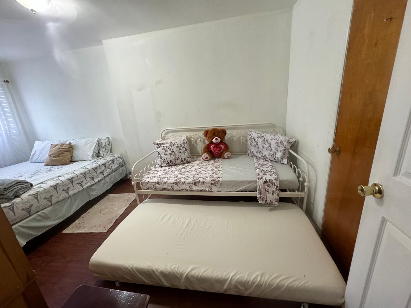 Una sistemazione compatta con una stanza singola, un letto, un divano e un orsacchiotto.