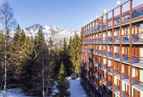 Ein mehrstöckiges Hotel mit Blick auf schneebedeckte Berge.