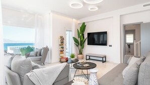 A modern living room with a sofa set, a coffee table, a TV, and a bookshelf.