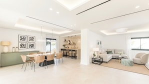 Una sala moderna con un sofá, una mesa de centro y un comedor con sillas y una mesa.