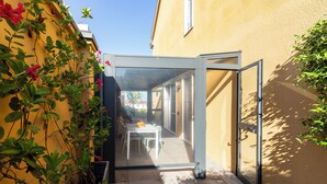 A narrow outdoor patio with a glass door leading to a dining area. - notaMI - HELLO Navigli (Milan)