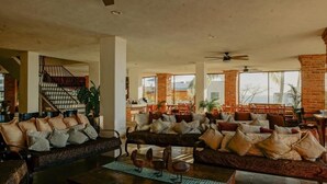 Amplia sala de estar con un sofá grande, una mesa de centro y una escalera.