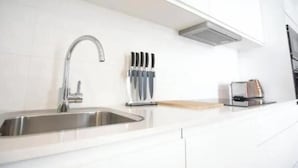 Une cuisine moderne équipée d’un évier en acier inoxydable, d’un bloc à couteaux et d’un grille-pain.