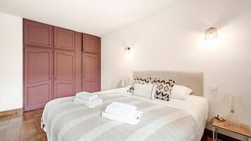 Une chambre à coucher avec un grand lit, une armoire et deux lampes de chevet.