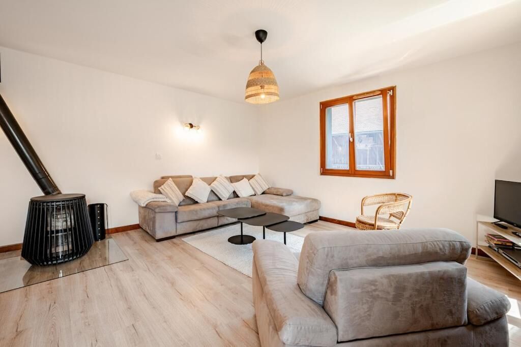 Ein modernes Wohnzimmer mit einer Couch, einem Couchtisch, einem Kamin und einem Fernseher.