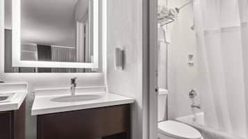 A modern bathroom with a large mirror, a sink, a toilet, and a shower area.