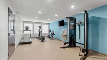 A fitness room with exercise equipment, a treadmill, and a wall-mounted TV.