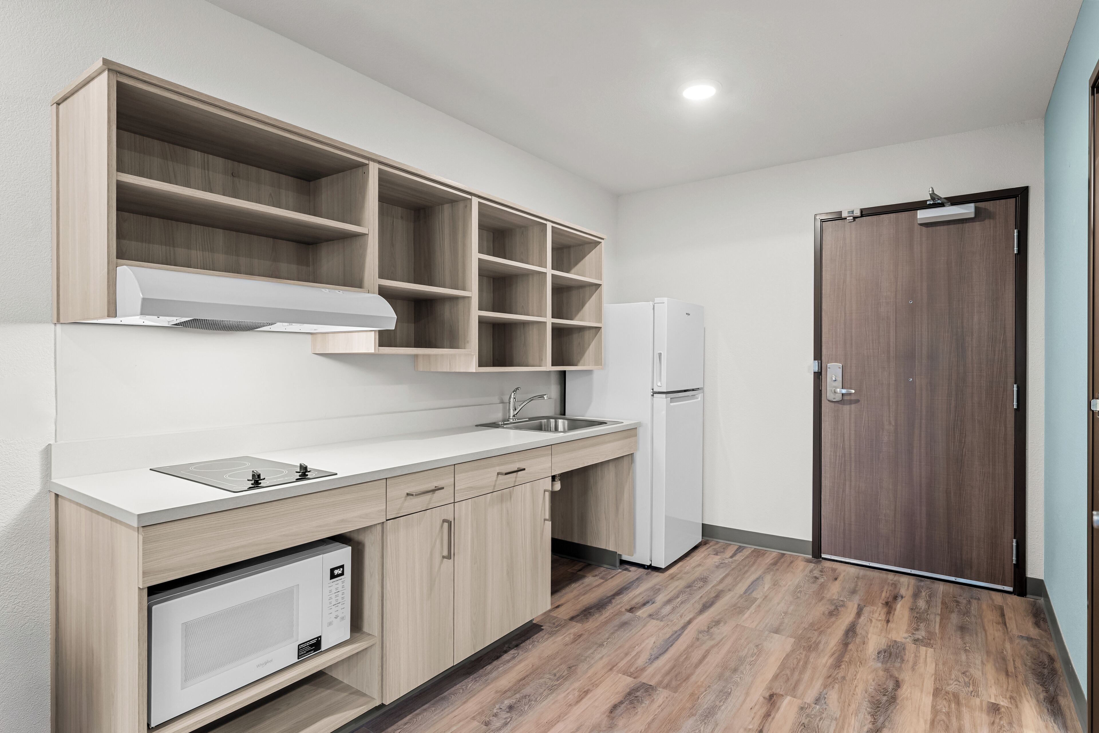 Una cocina moderna con microondas integrado, un lavaplatos y un refrigerador.
