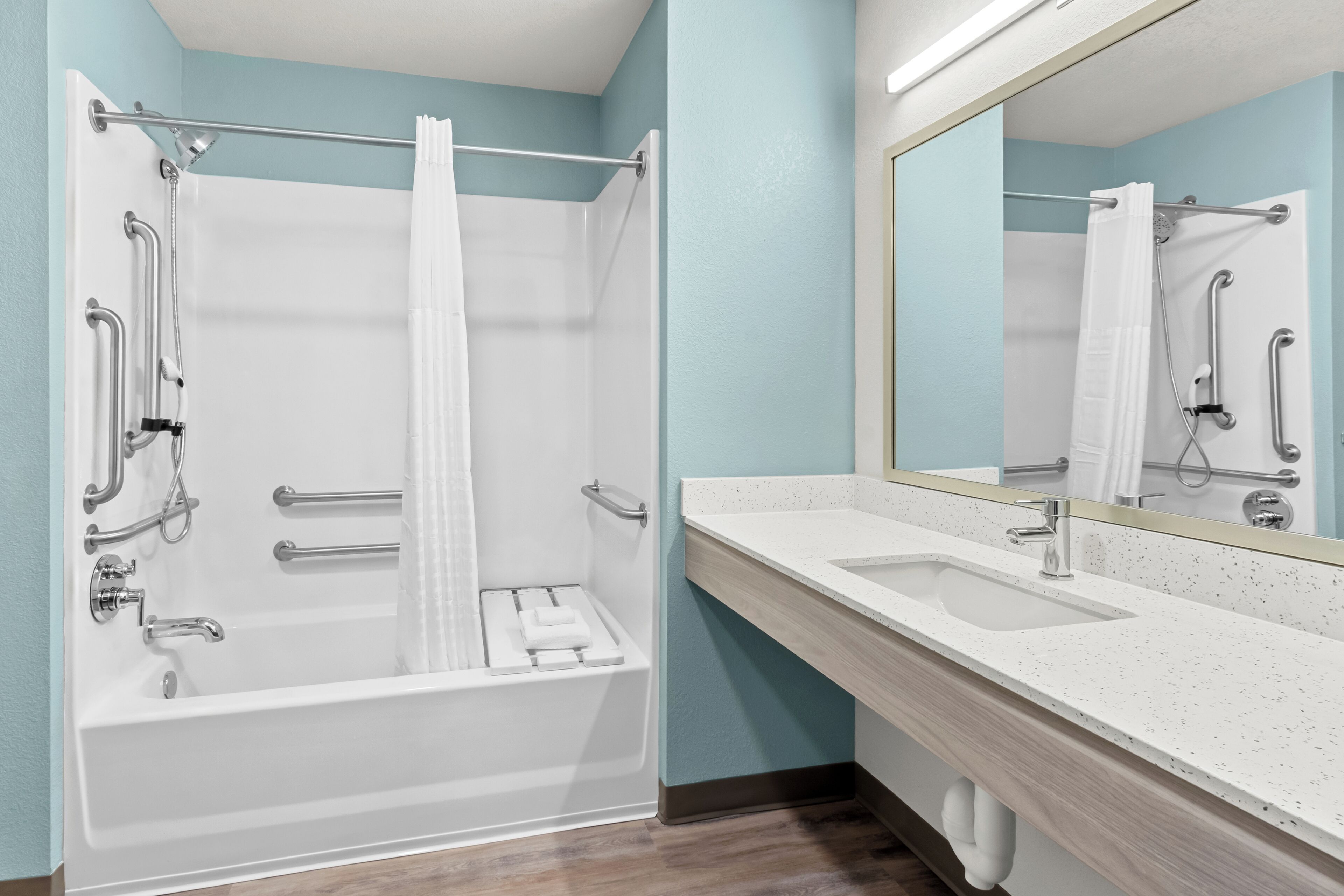 A modern bathroom with a bathtub, shower, and sink.