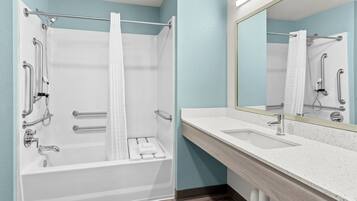 A modern bathroom with a bathtub, shower, and sink.