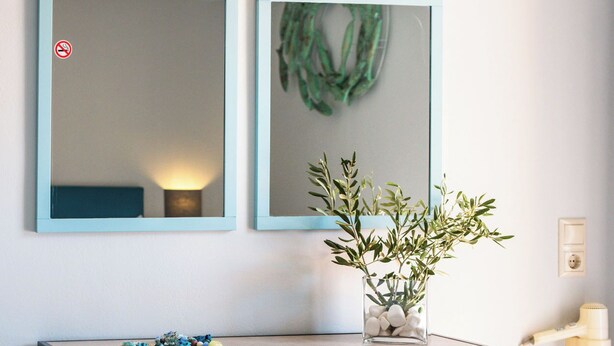 A modern desk with a chair, a wall-mounted mirror, and a small plant. - Makis Studios By La Skala Vista (Kefalonia)