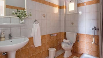 Un baño con lavamanos, inodoro y ducha.