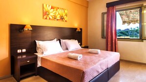 A hotel room with a large bed, two bedside lamps, a nightstand, and a window with curtains. - Makis Studios By La Skala Vista (Kefalonia)