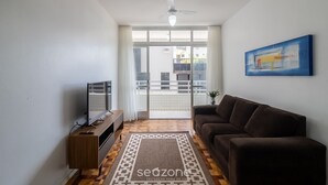 A living room with a sofa, TV, and a ceiling fan. - Beachfront Apartment With Side Beach View Ety0024 (Balneário Camboriú)